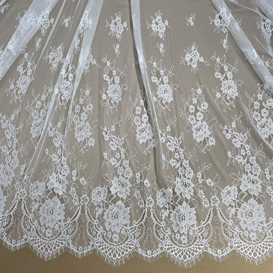 Close-up of Ivory/Off White  lace fabric with floral patterns on a brown background - LaceUSA-GDF-11