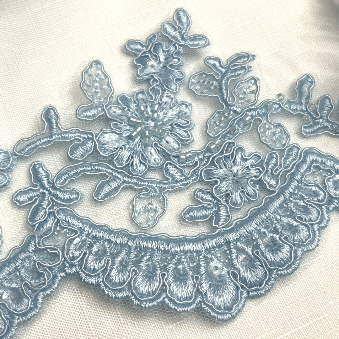 Closeup of Light blue beaded corded floral scalloped lace embroidered on polyester net mesh - LaceUSA 96215WHB