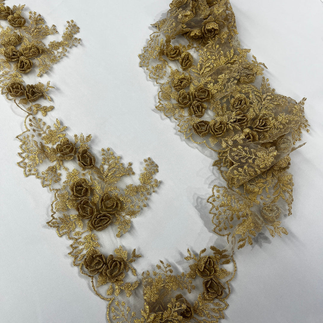 Gold lace trim with 3D rose motifs embroidered with metalic thread on 100% polyester net mesh,, featuring one flat unrolled length and one gathered bundle on a white background. LaceUSA #21853W
