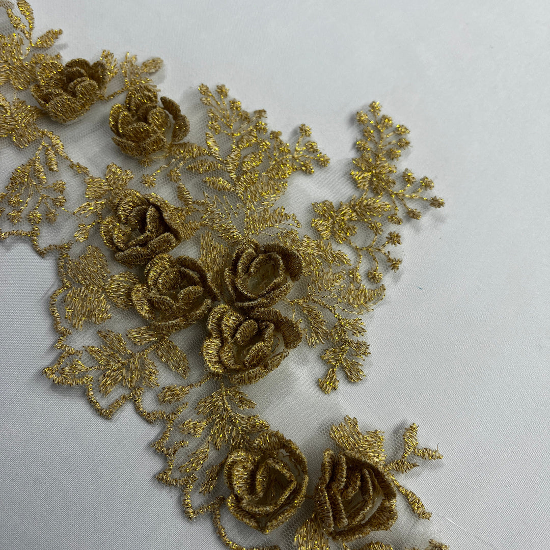 Closeup of  lace trim with 3D rose motifs embroidered with metalic thread on 100% polyester net mesh, on a white background. LaceUSA #21853W