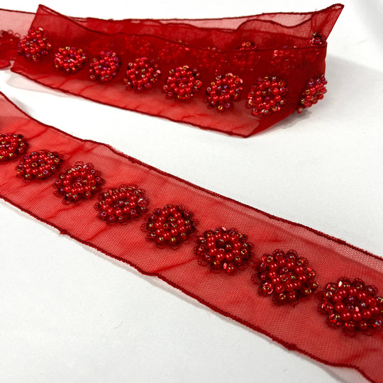 Red sheer net mesh trim ribbon with beaded & sequined  floral patterns, shown coiled and laid flat on a white background. Lace USA  #21766WNBP 